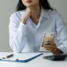 Young-person-calculating-Korean-net-salary-with-banknote-and-calculator.