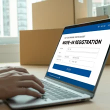 Hands-typing-on-a-laptop-displaying-the-Korean-government's-online-move-in-registration-service-website,-with-moving-boxes-blurred-in-the-background.