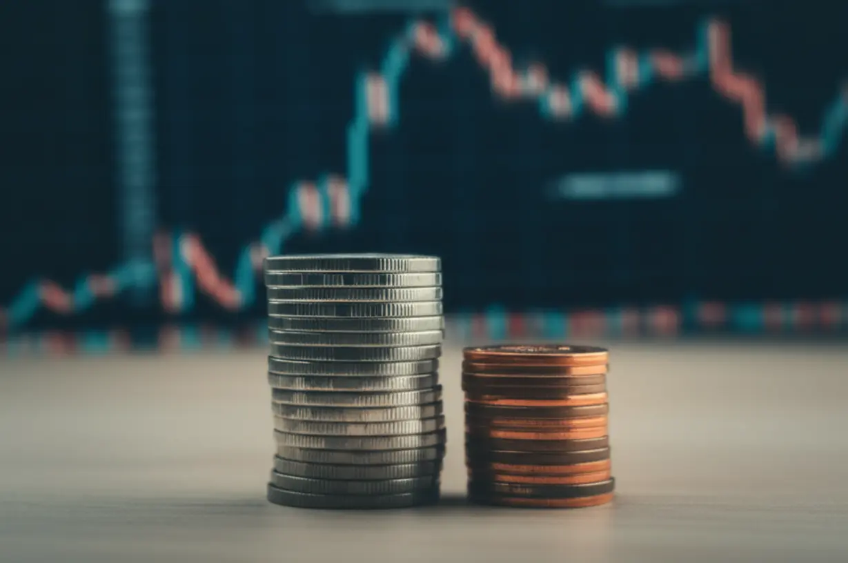 Two-unequal-stacks-of-money-with-a-financial-chart-in-the-background.