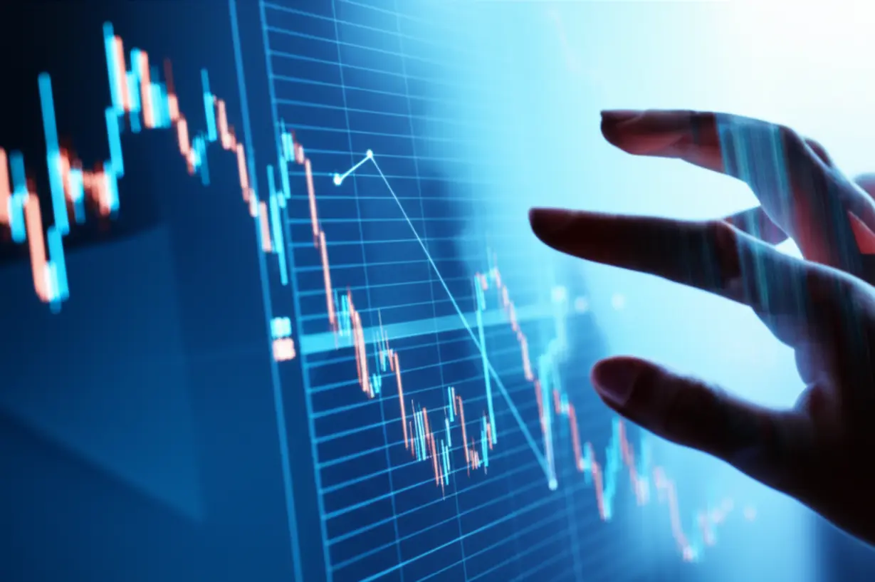 A-hand-adjusting-data-on-a-digital-screen-showing-a-fluctuating-graph.