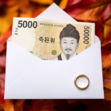 2025-결혼식-축의금-봉투와-5만원-지폐,-결혼반지가-놓인-가을-풍경.
